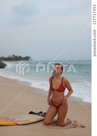 Smiling Lady Enjoying Sandy Shoreline. Caucasian Female Laughing By Ocean During Cloudy Weather 137717453