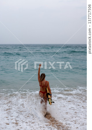 Surfer Waves Triumphs Energetically. Surfer Displays Triumphant Gesture Amid Crashing Waves And Spray Surfer Waves Triumphs Energetically. Surfer Displays Triumphant Gesture Amid Crashing Waves And Spray 137717506