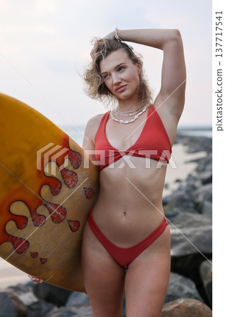 Elegant Woman With Surfboard And Jewelry. Fashion Shot Featuring Woman In Bikini With Necklace By Ocean Elegant Woman With Surfboard And Jewelry. Fashion Shot Featuring Woman In Bikini With Necklace By Ocean 137717541