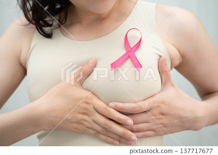Asian woman with pink ribbon for October world breast cancer day. Asian woman with pink ribbon for October world breast cancer day. 137717677