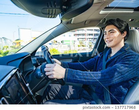 Photo of a smiling male driver driving a car 137717968