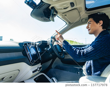 一名男司機指著他汽車的擋風玻璃。 137717978