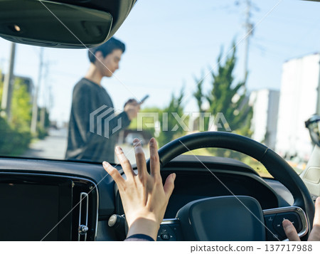 A man walking with a smartphone is nearly hit by a car 137717988