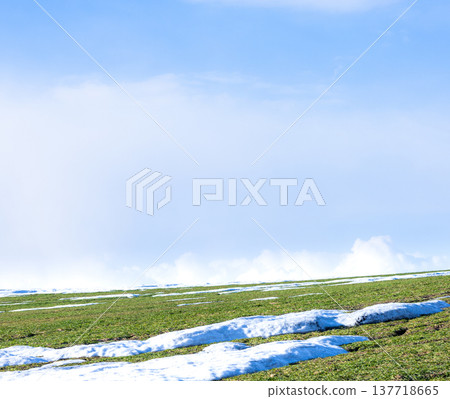 A landscape of wheat fields on a hill in Biei, Hokkaido, in early spring when snow still remains. 137718665