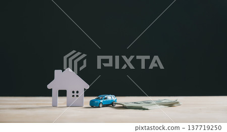 Home, car, property insurance and loan concept, white house model stands beside blue toy car and stack of dollar bills, representing real estate business financing or investment Home, car, property insurance and loan concept, white house model stands beside blue toy car and stack of dollar bills, representing real estate business financing or investment 137719250