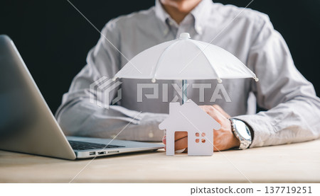 Business man demonstrating home insurance concept, protecting house property model with umbrella, illustrating financial security and mortgage safeguard protection for residence Business man demonstrating home insurance concept, protecting house property model with umbrella, illustrating financial security and mortgage safeguard protection for residence 137719251