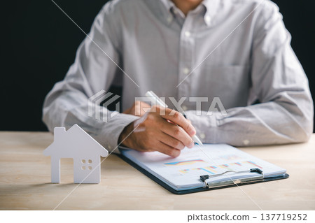 Estate planning involves man writing on financial documents, analyzing new property investment data, considering future home purchase or real loan concept for dream house 137719252