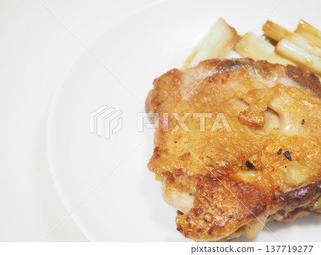 Chicken thigh sauté with green onions, with a composition that includes ample negative space. Chicken thigh sauté with green onions, with a composition that includes ample negative space. 137719277