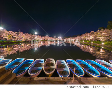 夜色中停泊著多艘小船,背景是盛開的櫻花倒映在水面上(青森縣弘前市)。 夜色中停泊著多艘小船,背景是盛開的櫻花倒映在水面上(青森縣弘前市)。 137719292