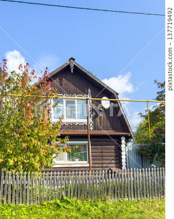 Traditional wooden house with decorative elements and surrounding greenery Traditional wooden house with decorative elements and surrounding greenery 137719492