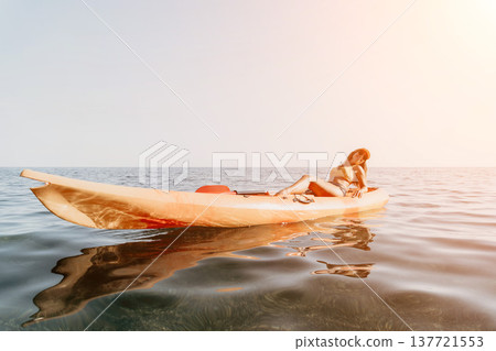 Kayaking Woman Sea Summer - A woman sits in a kayak paddling on the water during a summer day. 137721553