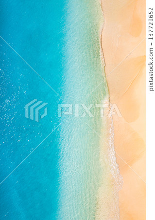 Aerial drone view of tropical summer seascape with turquoise ocean waves crashing on golden sandy beach, bright sunlight, serene coastal scenery, relaxing summer vacation paradise 137721652