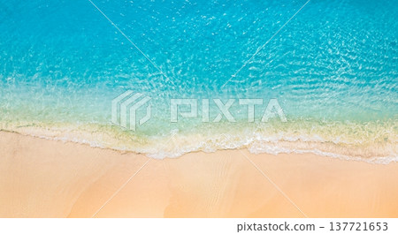Beautiful tropical summer seascape aerial shot of crystal clear blue ocean waves lapping golden sandy beach, soft sunlight at sunset, serene and idyllic nature landscape, perfect drone view for summer 137721653