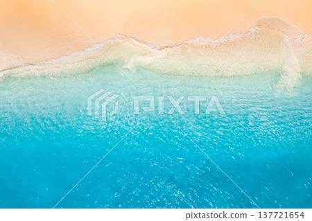 Panoramic tropical summer seascape from drone aerial view, vibrant blue ocean waves splashing on sandy beach, golden sunlight reflecting on water, serene nature background, idyllic vacation landscape 137721654