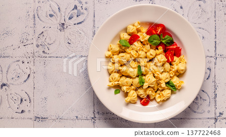 pasta in a plate with tomato sauce. 137722468