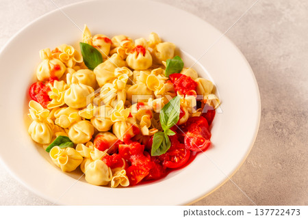 pasta in a plate with tomato sauce. 137722473