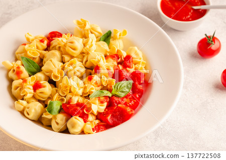 pasta in a plate with tomato sauce. 137722508