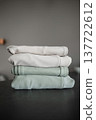 Stack of folded clothes on a dark surface with a plain background 137722612