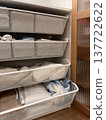 Organized storage unit with multiple baskets holding various items in a home setting 137722622