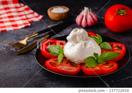 Caprese salad with tomatoes, burrata cheese and basil. 137722658