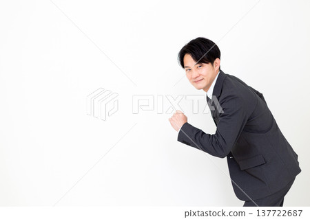 A middle-aged businessman in a suit strikes a running pose. 137722687