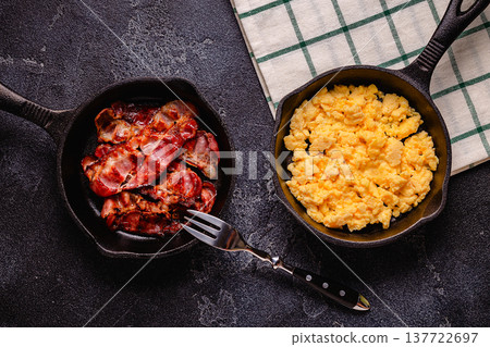 Cooked scrambled eggs and fried bacon in portion pans Cooked scrambled eggs and fried bacon in portion pans 137722697