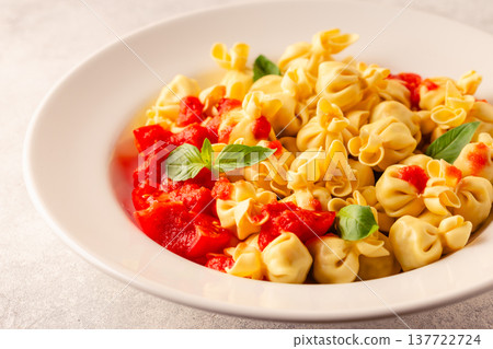 pasta in a plate with tomato sauce. 137722724