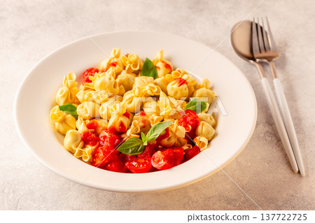 pasta in a plate with tomato sauce. 137722725