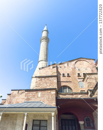 The architecture of the historic Hagia Sophia Mosque with a tall minaret against a clear blue sky. The architecture of the historic Hagia Sophia Mosque with a tall minaret against a clear blue sky. 137722820