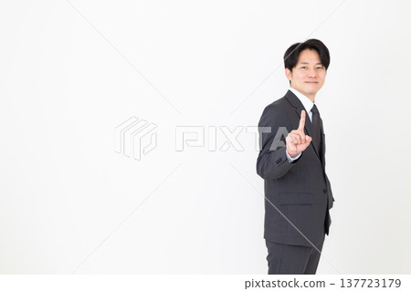 Middle-aged male businessman in a suit pointing his index finger 137723179