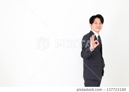 A middle-aged businessman in a suit making a circular pose. A middle-aged businessman in a suit making a circular pose. 137723180