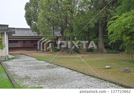 A gravel path leading to the Shiroyama Local History Museum at Uwajima Castle, where the castle keep still stands, and a charming wooden sign. 137723662