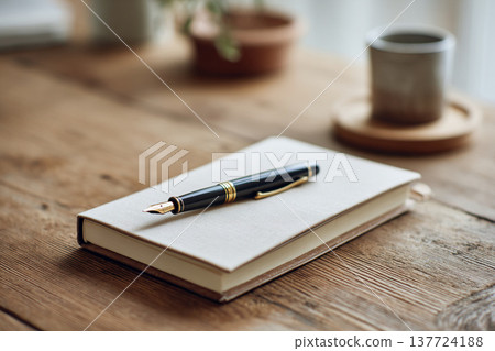 工作空間圖片，圖中可見鋼筆放在筆記本和木桌上。 137724188