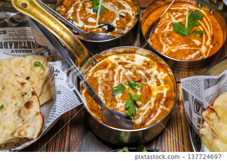 Various rich Indian curries served in traditional copper pots 137724697
