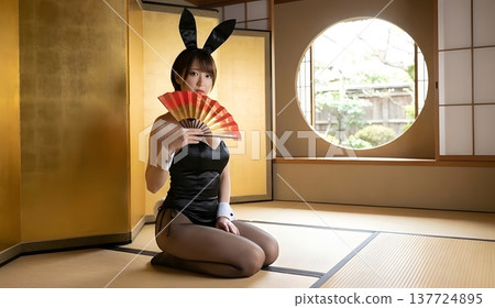 一位兔女郎坐在金色屏風前，手持扇子。 137724895