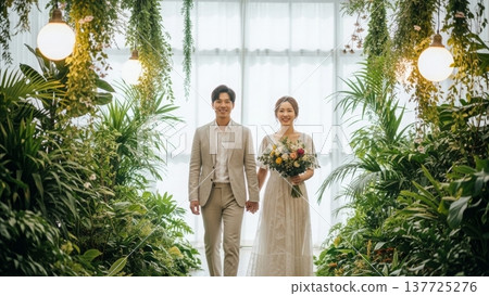 Wedding - Happy Korean Couple Walking Hand in Hand Through Lush Botanical Garden Aisle with Bouquet Wedding - Happy Korean Couple Walking Hand in Hand Through Lush Botanical Garden Aisle with Bouquet 137725276