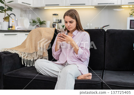 Young woman reads long work chat on smartphone facepalm types reply to resolve conflict under stress 137725405