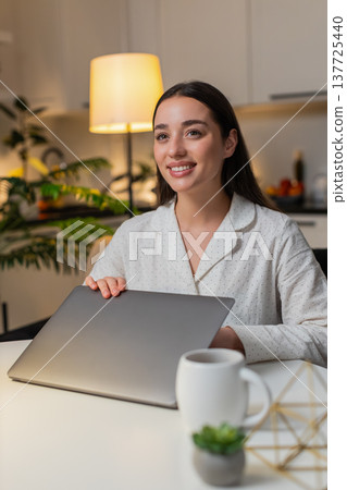 Young woman finishes tasks closes laptop exhales relax feels relief stress fades calm evening unwind Young woman finishes tasks closes laptop exhales relax feels relief stress fades calm evening unwind 137725440