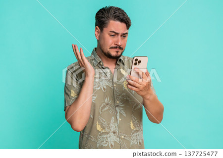Man frowning looking at smartphone screen receiving bad news or losing online game with frustration Man frowning looking at smartphone screen receiving bad news or losing online game with frustration 137725477