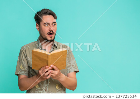 Man reading book with raised eyebrows showing surprise or interest in unexpected story twist moment Man reading book with raised eyebrows showing surprise or interest in unexpected story twist moment 137725534