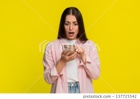 Woman panicking tapping smartphone screen reacting in fear after deleting something by mistake Woman panicking tapping smartphone screen reacting in fear after deleting something by mistake 137725542