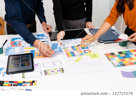 developer team brainstorming on their project with laptop, smartphone and digital tablet. developer team brainstorming on their project with laptop, smartphone and digital tablet. 137725579