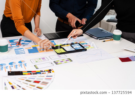 developer team brainstorming on their project with laptop, smartphone and digital tablet. developer team brainstorming on their project with laptop, smartphone and digital tablet. 137725594