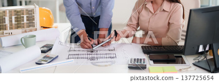 Asian architects engineers collaborating design new building plans office discussing project development safety helmet model working professionally construction industry Asian architects engineers collaborating design new building plans office discussing project development safety helmet model working professionally construction industry 137725654