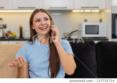 Young woman talks on smartphone dialogue enjoys voice call smiles listens with interest and energy 137725714