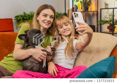 Mother daughter dog playful selfie with smartphone mask filter laugh together cheerful family photo 137725833
