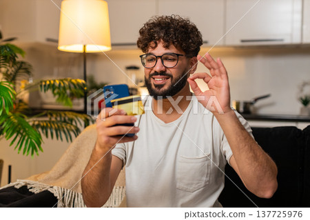 Arabian man confirms online card payment on smartphone checks discount makes ok sign saves e receipt 137725976