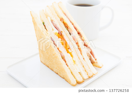 早餐是美味的俱樂部三明治和咖啡。 早餐是美味的俱樂部三明治和咖啡。 137726258