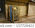 A shopping cart and shutters left in the shopping street after closing time. 137726422