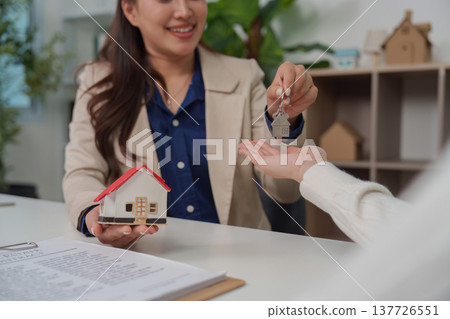 Home Purchase. Real estate agent handing over keys to new homeowner during consultation. 137726551